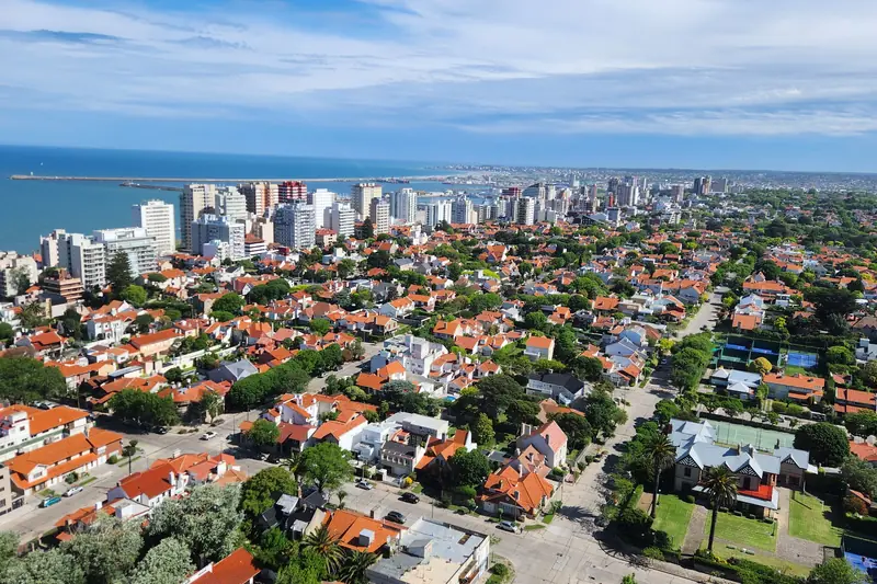 Vista aérea de un barrio residencial de Mar del Plata, con casas de tejas y las torres de la costa al fondo